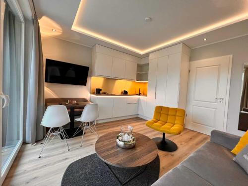 a living room with a table and a yellow chair at DRIEHOF LifeStyle Comfort Apt 4 in Tecklenburg