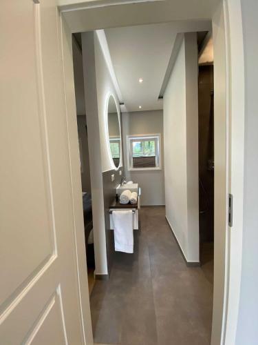 a hallway with a bathroom with a sink and a mirror at DRIEHOF LifeStyle Comfort Apt 4 in Tecklenburg