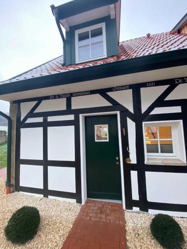 a carriage house with a green garage door at DRIEHOF LifeStyle Suite Apt 1 in Tecklenburg