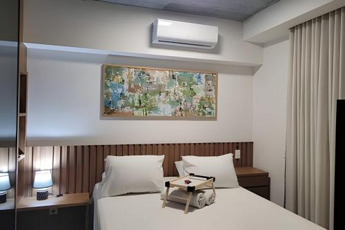 a hotel room with a bed with a table on it at Vida Urbana - Allegro - Setor Oeste in Goiânia