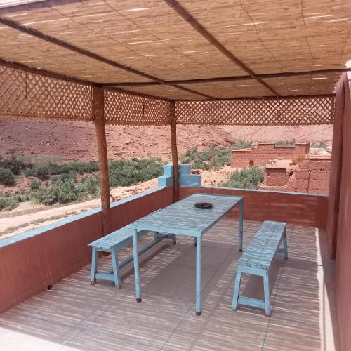 a blue table and a bench on a porch at Dar Brahim Resto Beds in Ouarzazate
