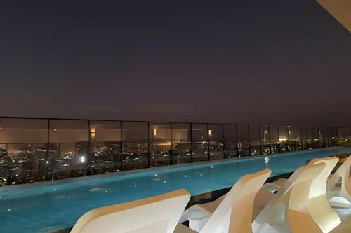 a hotel swimming pool with a city view at night at Vida Urbana - Allegro - Setor Oeste in Goiânia