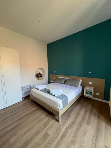a bedroom with a large bed with a green wall at Dimora Marconi in Vibo Valentia