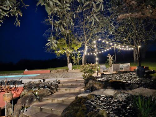 un patio avec des lumières et des escaliers la nuit dans l'établissement Magnifique Villa privative avec Piscine et Spa pour 15 personnes, à La Tessoualle