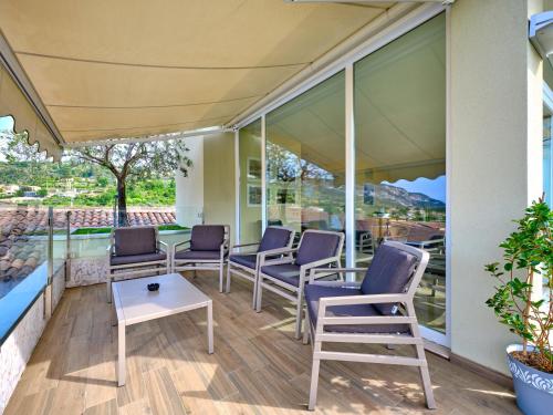 a porch with chairs and a table and windows at Hotel Eden Garda in Garda