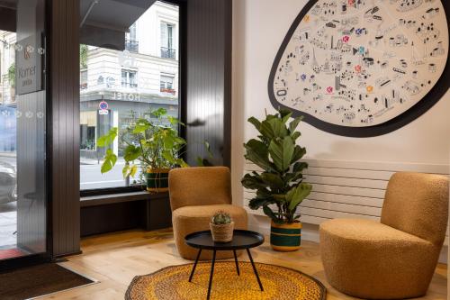 une chambre avec deux chaises et une horloge sur le mur dans l'établissement Korner Opera, à Paris