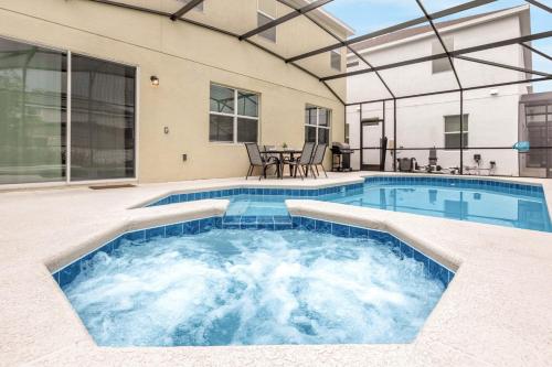 a swimming pool in the middle of a house at Upstay Ultimate Orlando Retreat w Pool & Hot Tub Sleeps 16 in Kissimmee