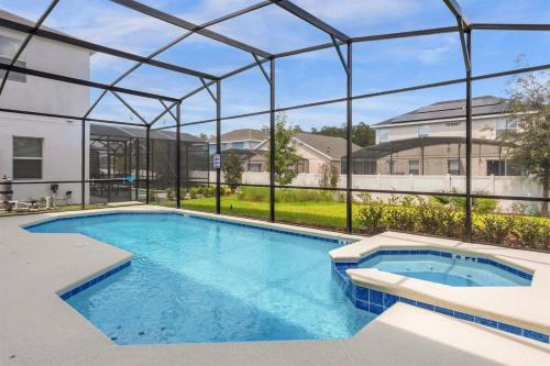 a large swimming pool with a clear cover over it at Upstay Ultimate Orlando Retreat w Pool & Hot Tub Sleeps 16 in Kissimmee
