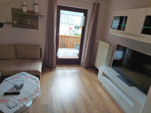 a living room with a couch and a television at Haus Marina Apartment Bergkristall mit Gratis Eintritt Alpentherme in Bad Hofgastein