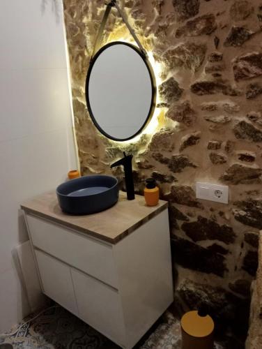 a bathroom with a mirror and a sink on a dresser at Apartamentos Muralla Sacra in Sober