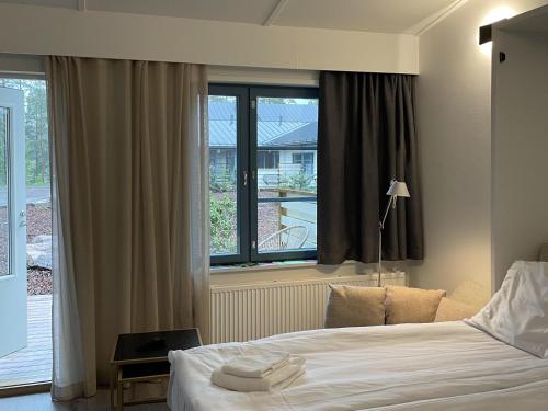 a bedroom with a bed and a large window at Polku Hotelli in Vihti