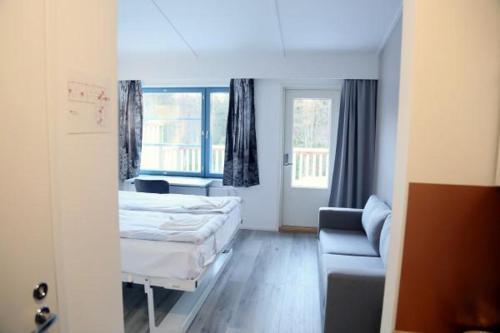 a hotel room with a bed and a couch at Polku Hotelli in Vihti