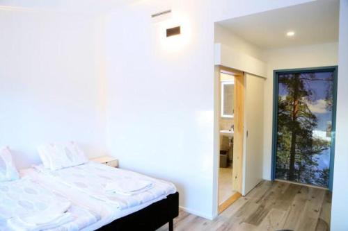 a bedroom with a bed and a large window at Polku Hotelli in Vihti