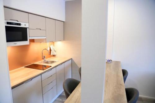 a kitchen with a sink and a counter with chairs at Polku Hotelli in Vihti