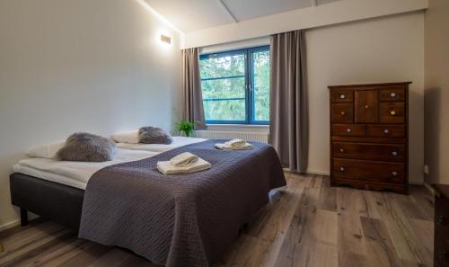 a bedroom with a bed and a dresser and a window at Polku Hotelli in Vihti