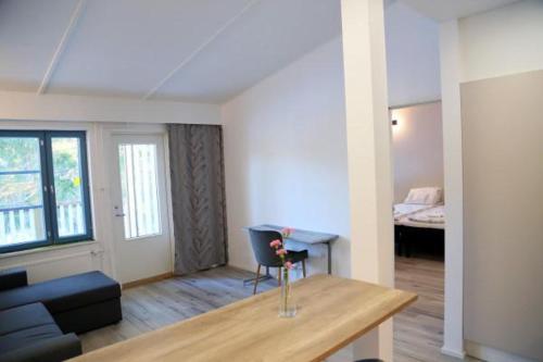 a living room with a table and a couch and a bed at Polku Hotelli in Vihti