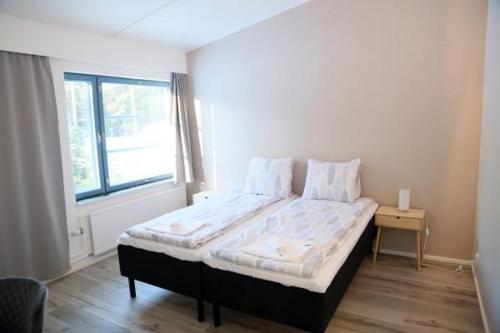 a large bed in a room with a window at Polku Hotelli in Vihti