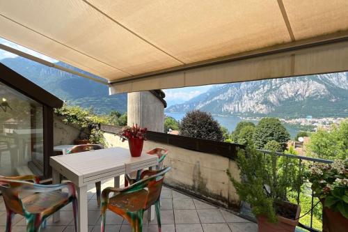 a white table and chairs on a balcony with a view at House Bluette - Affitti Brevi Italia in Malgrate