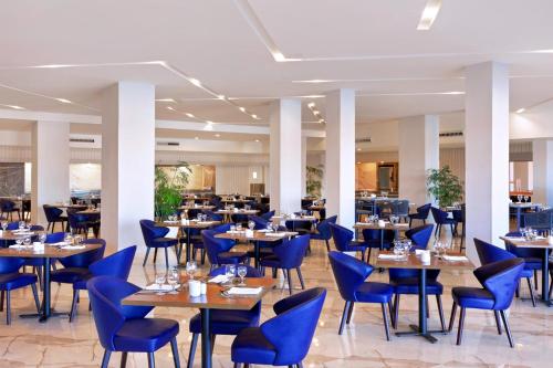 沙姆沙伊赫Pickalbatros Laguna Vista Aqua Park - 24 HRS All Inclusive的配有蓝色椅子和桌子的餐厅