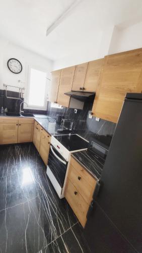 une cuisine avec des armoires en bois et un four à plaques de cuisson dans l'établissement appartement familial refait à neuf centre Paris 20ème, à Paris