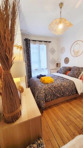 - une chambre avec un lit et une table avec un vase dans l'établissement appartement familial refait à neuf centre Paris 20ème, à Paris