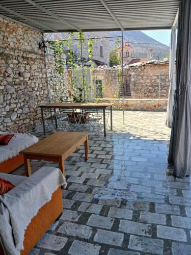 a patio with two tables and a stone wall at SUNSHINE in Bríkion