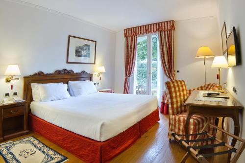 a bedroom with a bed and a desk and a chair at Borgo Cà dei Sospiri in Quarto dʼAltino