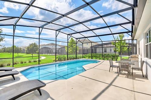 a patio with a pool and tables and chairs at Family Resort - 6BR Mansion - Private Pool, Home Theater, BBQ and More in Kissimmee