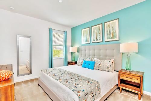 a bedroom with a bed and a blue wall at Family Resort - 6BR Mansion - Private Pool, Home Theater, BBQ and More in Kissimmee