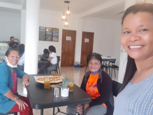 a group of women sitting around a table with a plate of food at The Soul Center in Batuan