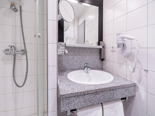 a bathroom with a sink and a mirror at Best Western Hotel Heidehof in Hermannsburg