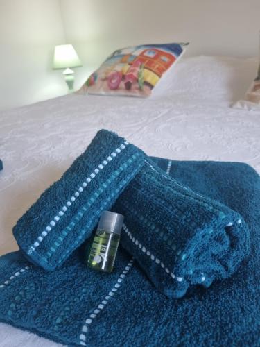 a blue blanket and a bottle of medicine on a bed at Villa Maddalena guest house in Sorso