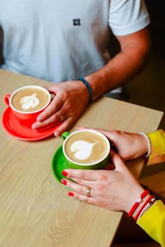two people holding cups of coffee on a table at Grand Hotel Coroana in Bistriţa