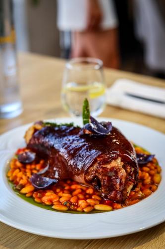 a white plate of food with a chicken and beans at Grand Hotel Coroana in Bistriţa