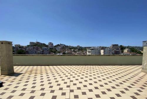 Una habitación con suelo de cuadros y una ciudad. en Durres Dream Escape, en Durrës