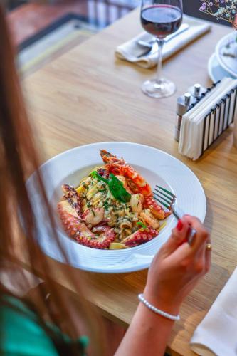 a woman eating a plate of food on a table at Grand Hotel Coroana in Bistriţa