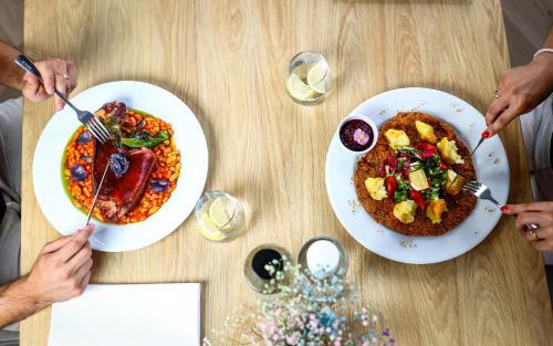 two people sitting at a table with plates of food at Grand Hotel Coroana in Bistriţa