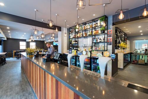 バサーストにあるThe George Hotel Bathurstのレストランのバーに立つ男