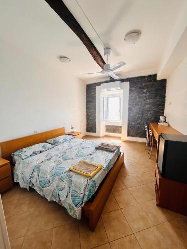 a bedroom with a bed and a desk and a television at affittacamere nuova Vandiris in Manarola