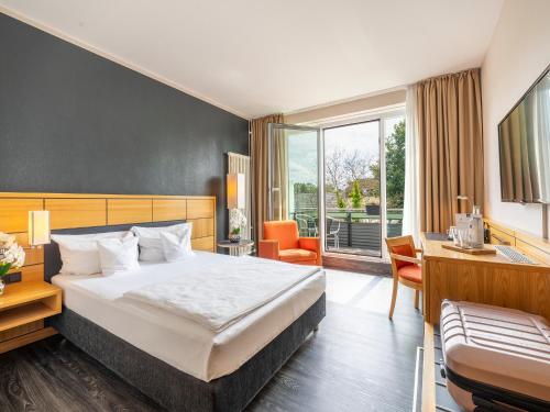 a hotel room with a bed and a desk and a chair at Best Western Hotel Heidehof in Hermannsburg