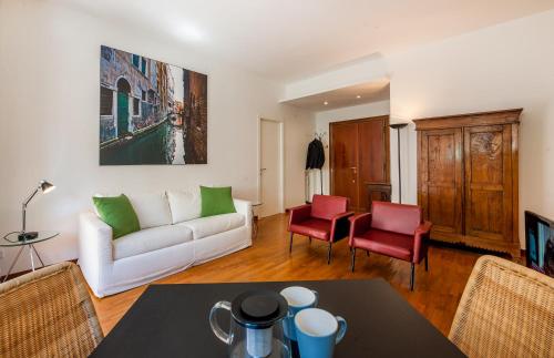 sala de estar con sofá blanco y sillas rojas en Magenta Collection Fornaci, en Roma