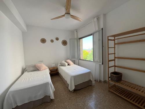 Un dormitorio con dos camas y una ventana. en Ca la Pepeta i Josep, en Deltebre