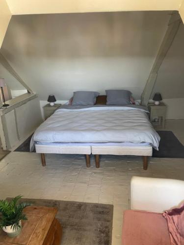 une chambre avec un grand lit avec des oreillers bleus dans l'établissement Appartement Honfleur, à Honfleur