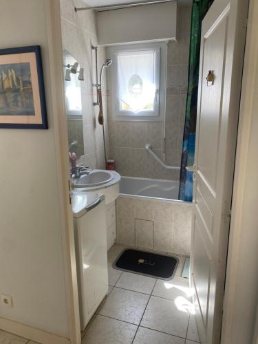 une salle de bain avec une baignoire, un lavabo et une douche dans l'établissement Appartement 3 pièces de 52 m2 face au port du Crouesty avec terrasse de 18 m2 parking privé et wifi gratuit, à Arzon