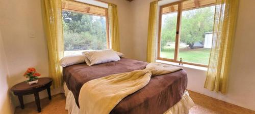a bedroom with a bed and a large window at Casa Ecológica Al Pie Del Volcán in Otavalo