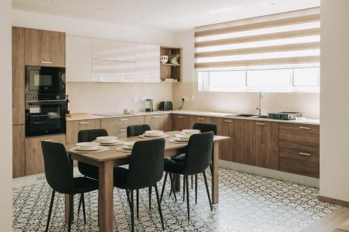 a kitchen with a table and chairs in a kitchen at B5 The Palm Court Apartment in St Paul's Bay