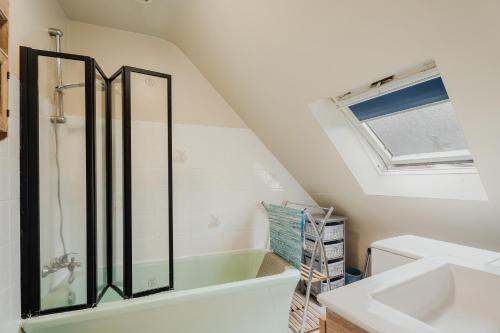 une salle de bain avec un lavabo et une baignoire dans l'établissement Appartement Du Bonheur, à Baguer-Pican