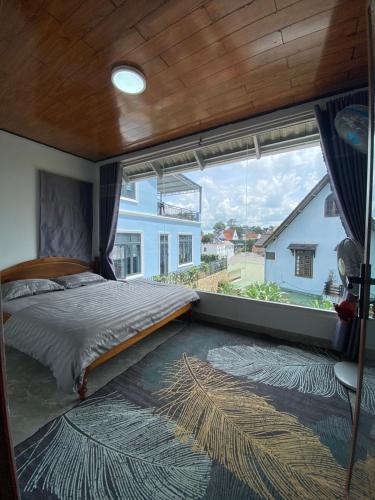 a bedroom with a bed and a large window at MIA Villa Đà Lạt in Khu Chi Lăng
