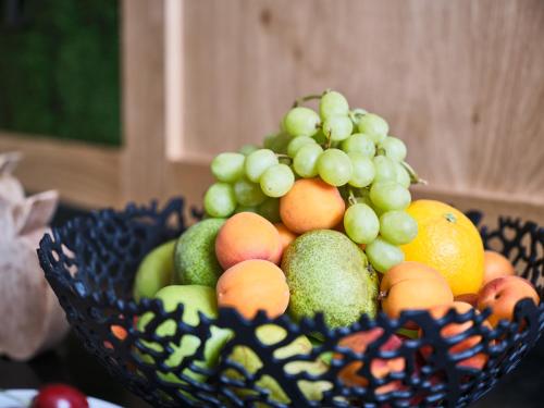 a bowl of fruit with grapes apples and oranges at Bloberger Hof in Salzburg