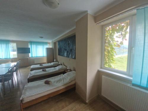 two beds in a room with a window at Penzion Flipper in Revúca
